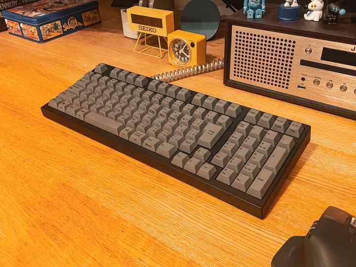 暖かみのある木目調のデスクに、90年代風レトロデザインのARCHISSキーボードが置かれた雰囲気のある空間