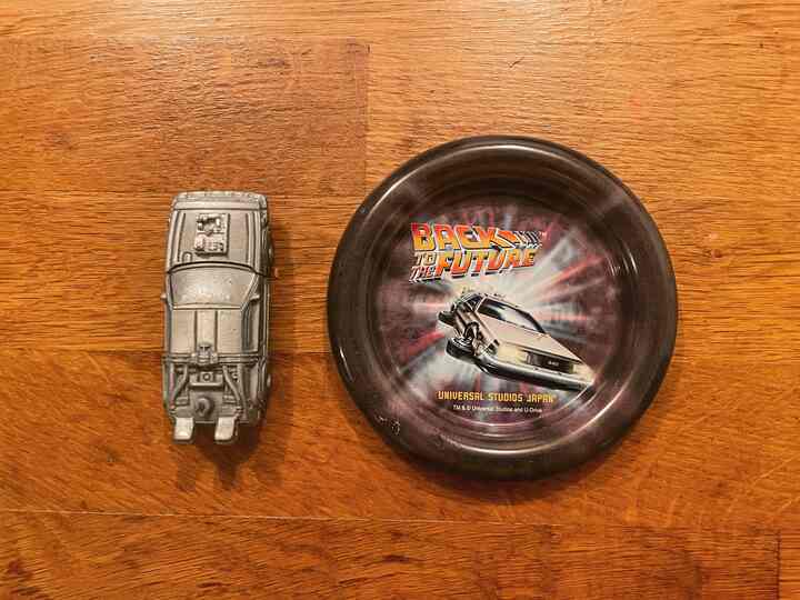 茶色の木目調キッチンアイランド、シルバーのデロリアンライターとバック・トゥ・ザ・フューチャーの小皿が配置された印象的な空間