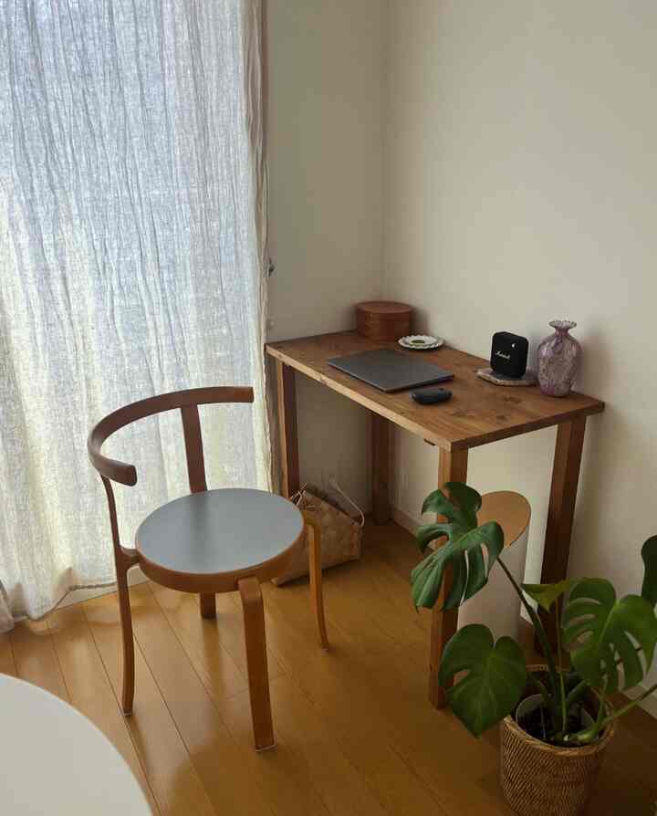 ナチュラルな木目調のトーンが特徴のホームオフィス空間、シンプルで温かみのある木製デスクとアームチェアが配置された印象的なインテリア。