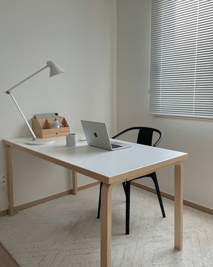 ホワイトと木目調が調和したコンパクトなホームオフィス、シンプルでミニマルな机とオフィスチェアが配置された雰囲気のあるインテリア