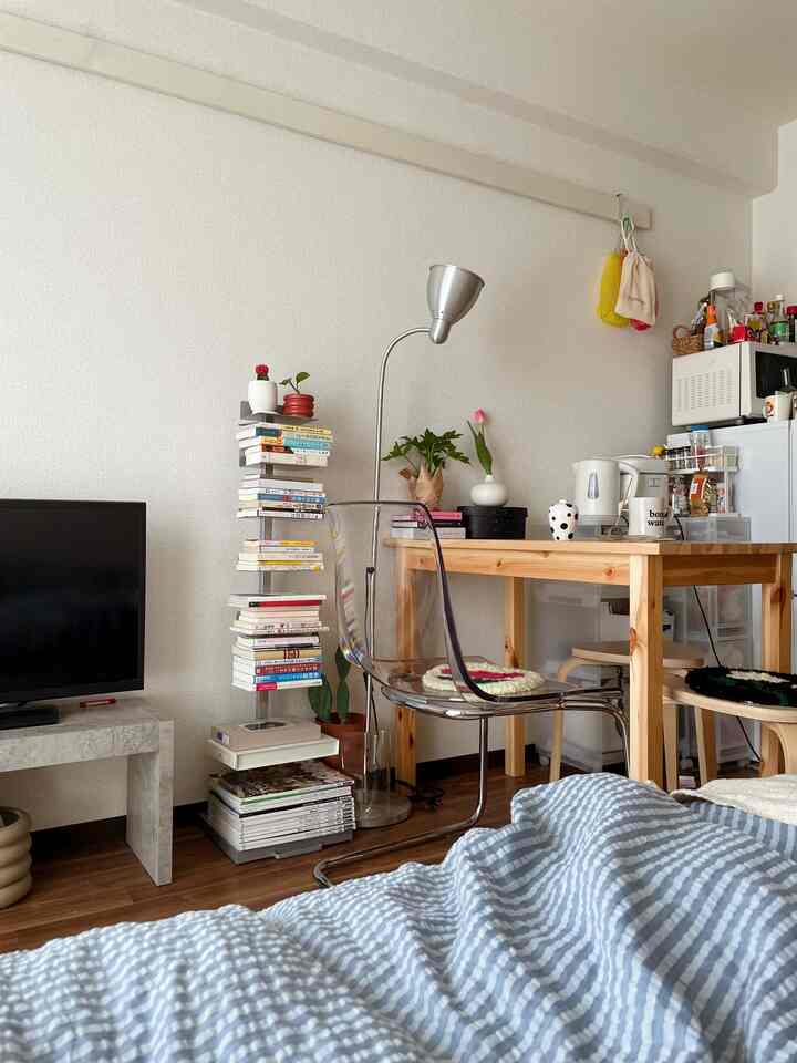 ナチュラルトーンと透明椅子の一人暮らし用コンパクトなダイニング空間。読書やおうちカフェの要素が調和した落ち着いた雰囲気のインテリア