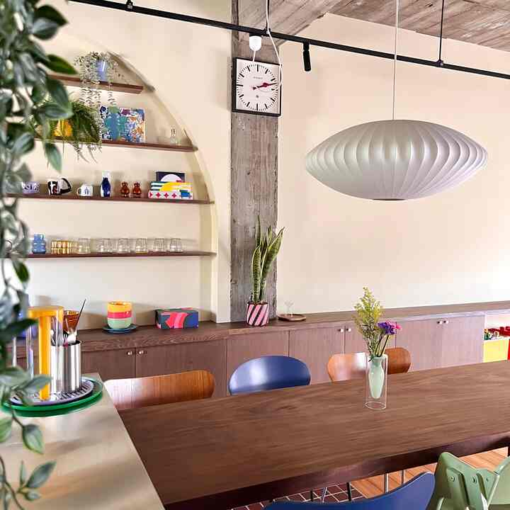ナチュラルな木目調と白を基調としたダイニング、中央にジョージ・ネルソンのバブルペンダントライトが配置された雰囲気のあるインテリア