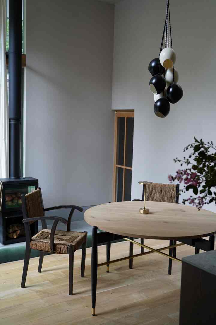 木目調の床と円形ダイニングテーブル、2脚のアームチェアが配置されたシンプルでナチュラルなダイニング