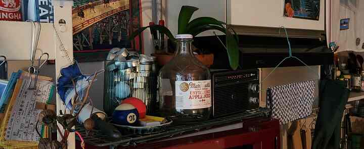 ナチュラルな雰囲気の狭いキッチン、様々なキッチンタオルとゴム手袋が配置された印象的な空間