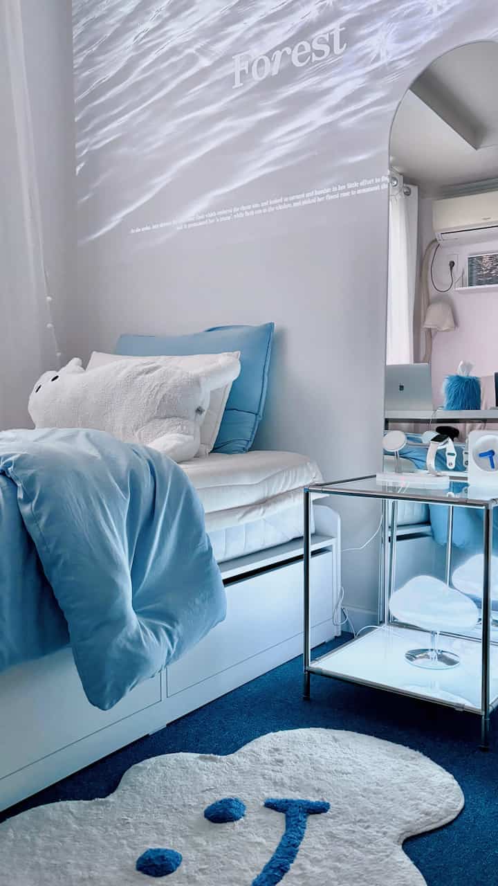 白と青のトーンの寝室、雲型ムードランプと収納を備えたモダンなインテリア空間