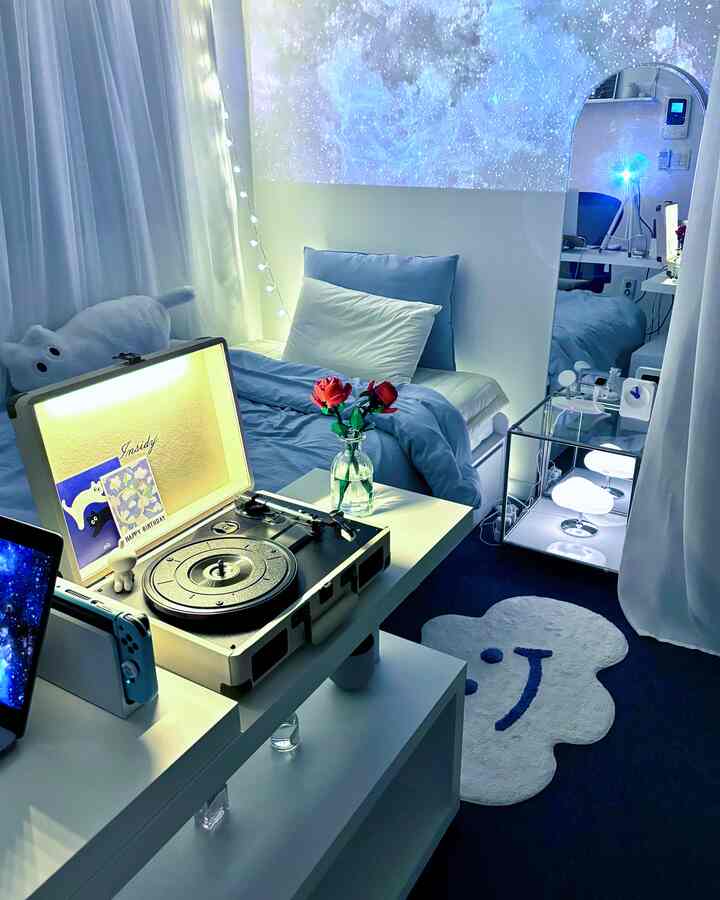 白と青のトーンの寝室、短焦点プロジェクターが壁に星空を映し出す雰囲気のあるインテリア