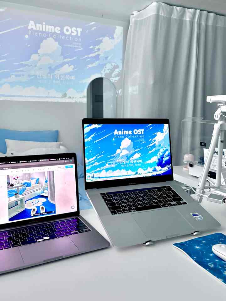 白と青のトーンが特徴のホームオフィス空間、2台のノートパソコンとプロジェクターが配置された整ったデスク環境