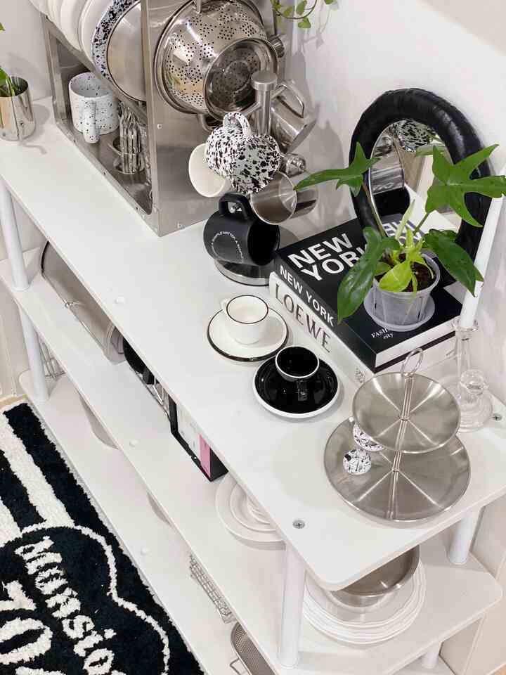 白とシルバーの色調が特徴的なキッチン棚に多様な食器とコーヒーカップが整然と配置されたモダンなおうちカフェ空間