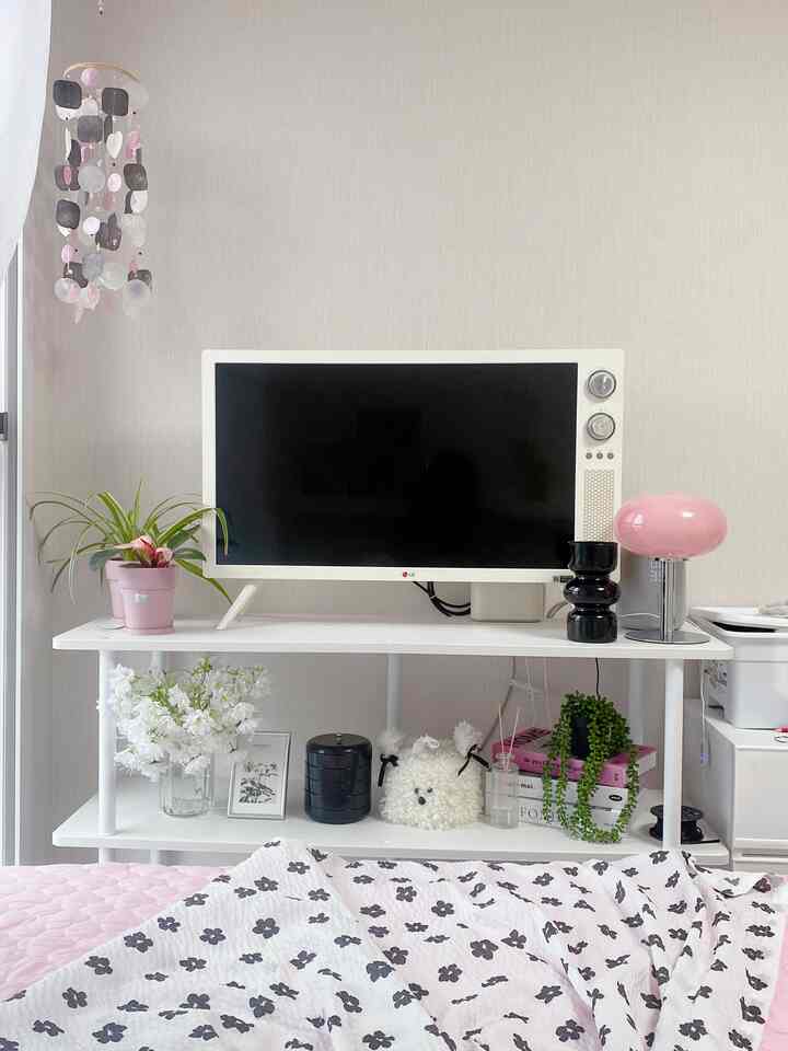 ホワイトとナチュラルカラーの壁の寝室、中央にテレビと棚が配置された雰囲気のあるインテリア