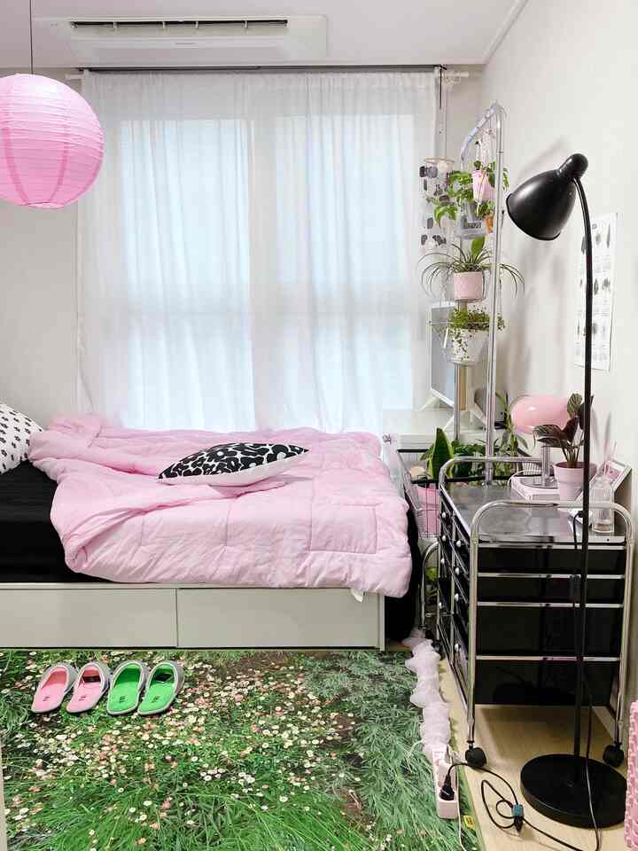 ピンクと白の色調の寝室、花柄のラグと多目的収納キャビネットが配置された雰囲気のあるインテリア