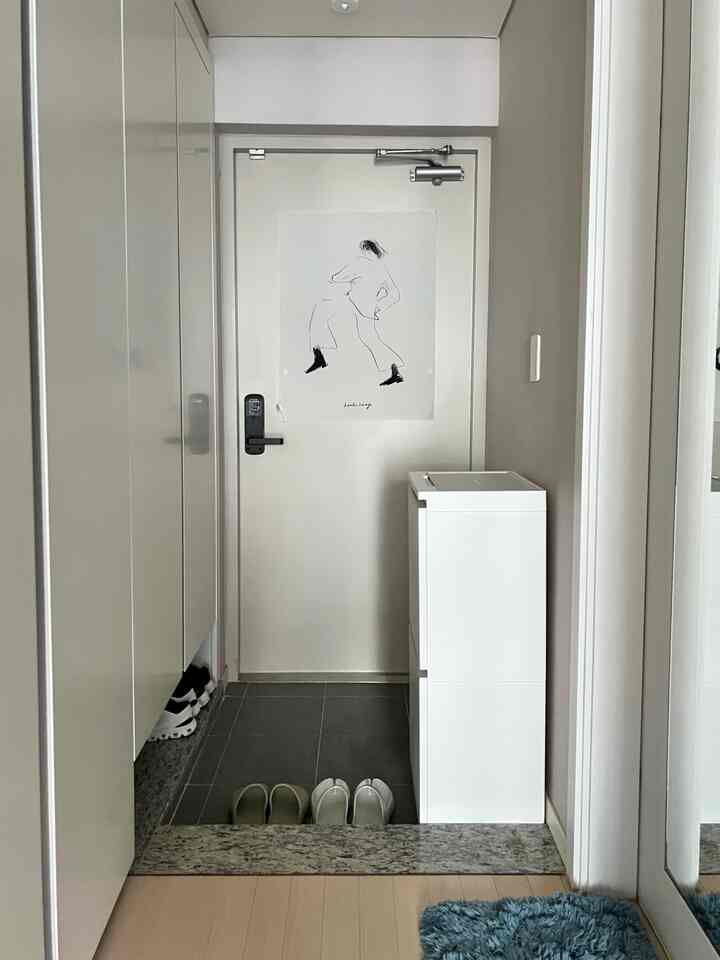 白を基調としたシンプルな玄関、分別ごみ箱と靴箱が配置された整った空間