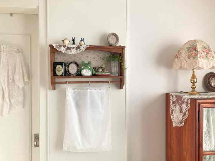 白い壁と茶色い木製の壁棚が配置された、温かみのあるビンテージ風のナチュラルなインテリア空間