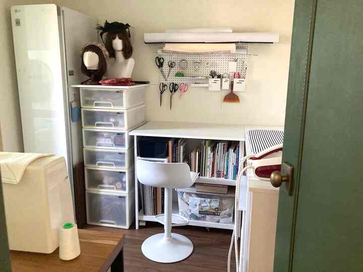 白と茶色のトーンのワークスペース、白い机と椅子が配置され整理された収納スペース