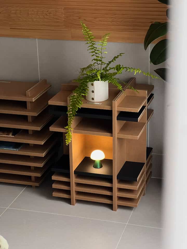 ナチュラルカラーのリビングの一角、サイドテーブルに植物と小さなムードランプが配置されたシンプルな空間