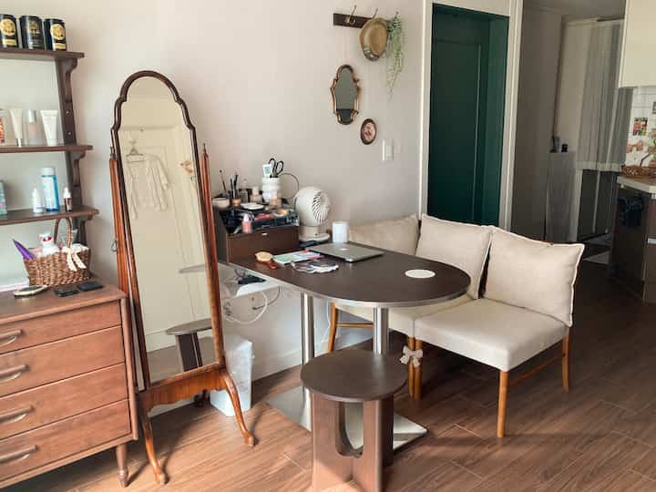 ブラウンの木目調とベージュのクッションが調和したナチュラルモダンなリビング・ダイニング空間