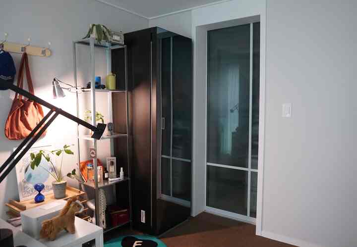 ホワイトとブラックのトーンが調和するウォークインクローゼットとワークスペースを備えたシンプルでモダンな室内。