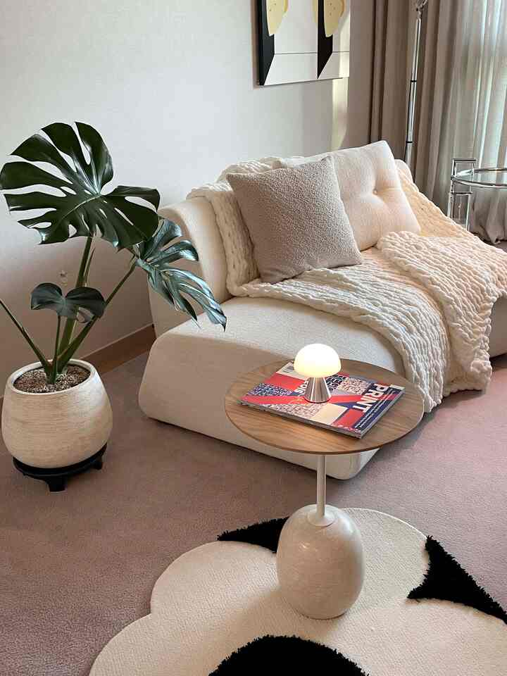 ホワイトとベージュのトーンのリビング、ナチュラルなソファと木製コーヒーテーブルが配置された落ち着いた空間