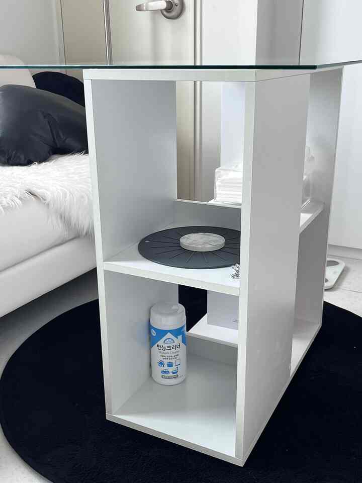 白黒のトーンのキッチン、収納キャビネットと黒い円形のラグが配置された印象的な空間