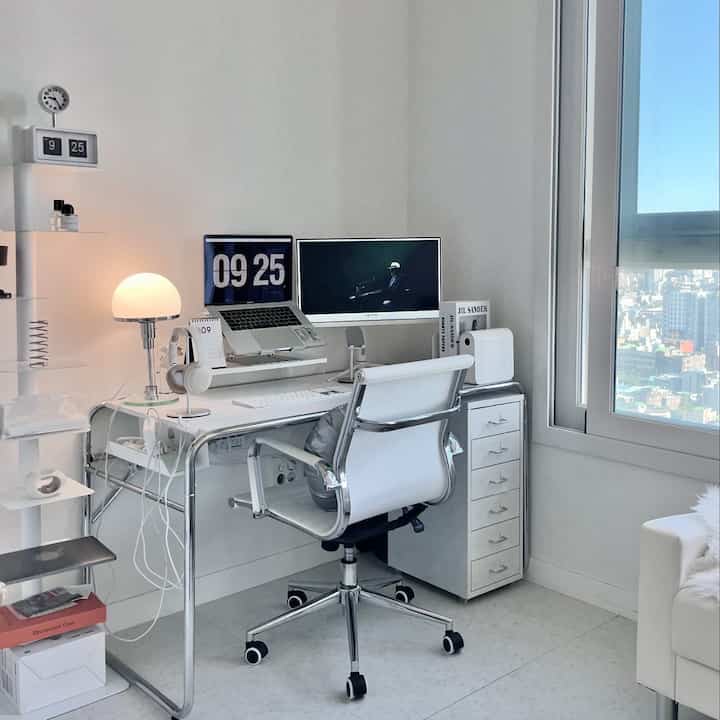 白とステンレスのトーンのホームオフィス、ミッドセンチュリーモダンな印象的なデスクとチェアが配置された空間