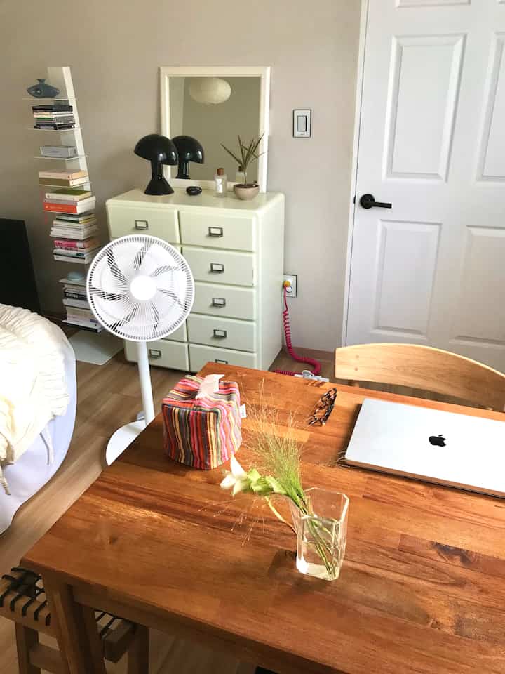 ナチュラルな木目調とシンプルな家具が配置された落ち着いた寝室兼作業スペース