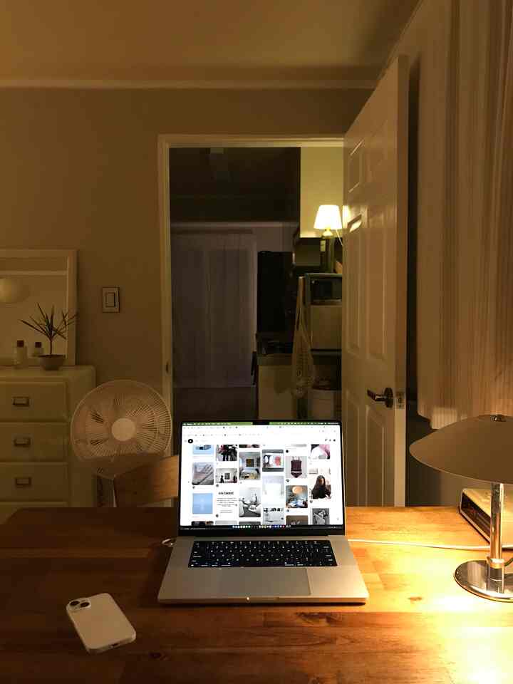 温かみのある照明と木製デスクが配置されたモダンでコンパクトなホームオフィスの雰囲気あるインテリア