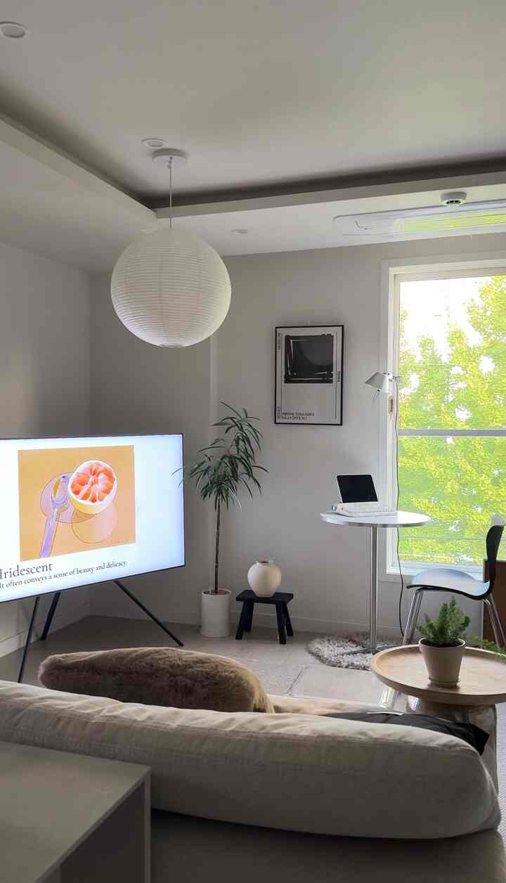 白を基調としたリビング、ミッドセンチュリーモダンのダイニングチェアと小さな丸テーブルが配置された落ち着いた雰囲気のあるインテリア