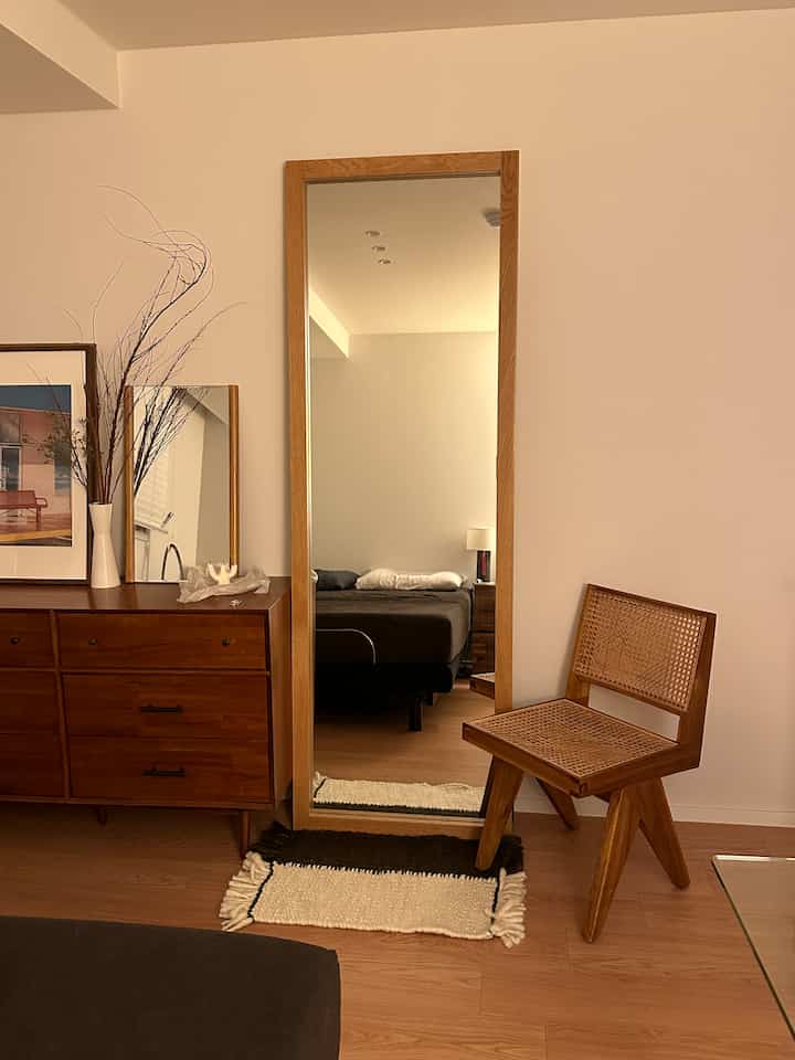 木目調のナチュラルな寝室、全身鏡とドレッサー、木製チェアが配置された落ち着いた空間
