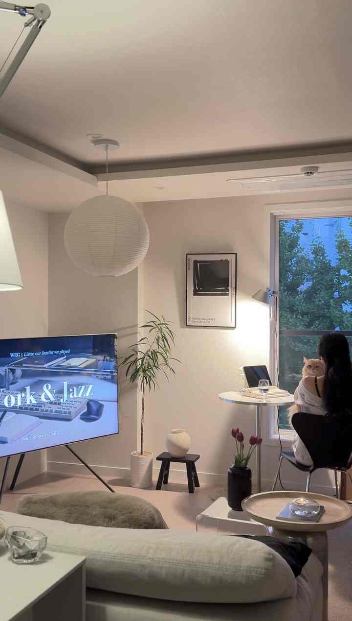 柔らかなホワイトとベージュのトーンのリビング、ミッドセンチュリーモダン家具と猫と一緒の温かみのあるインテリア