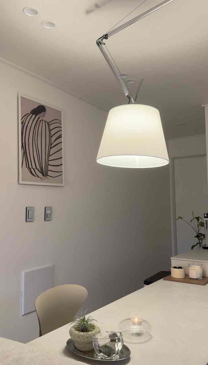 明るい白を基調としたダイニング、シンプルなダイニングチェアとペンダントライトが配置されたモダンで落ち着いた空間