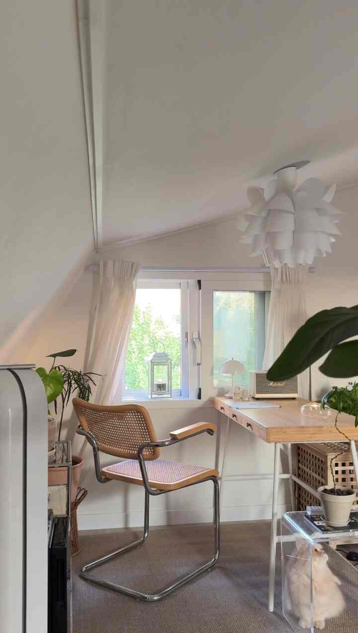 白と木目調のホームオフィス、窓際にデスクと椅子が配置された雰囲気のある空間