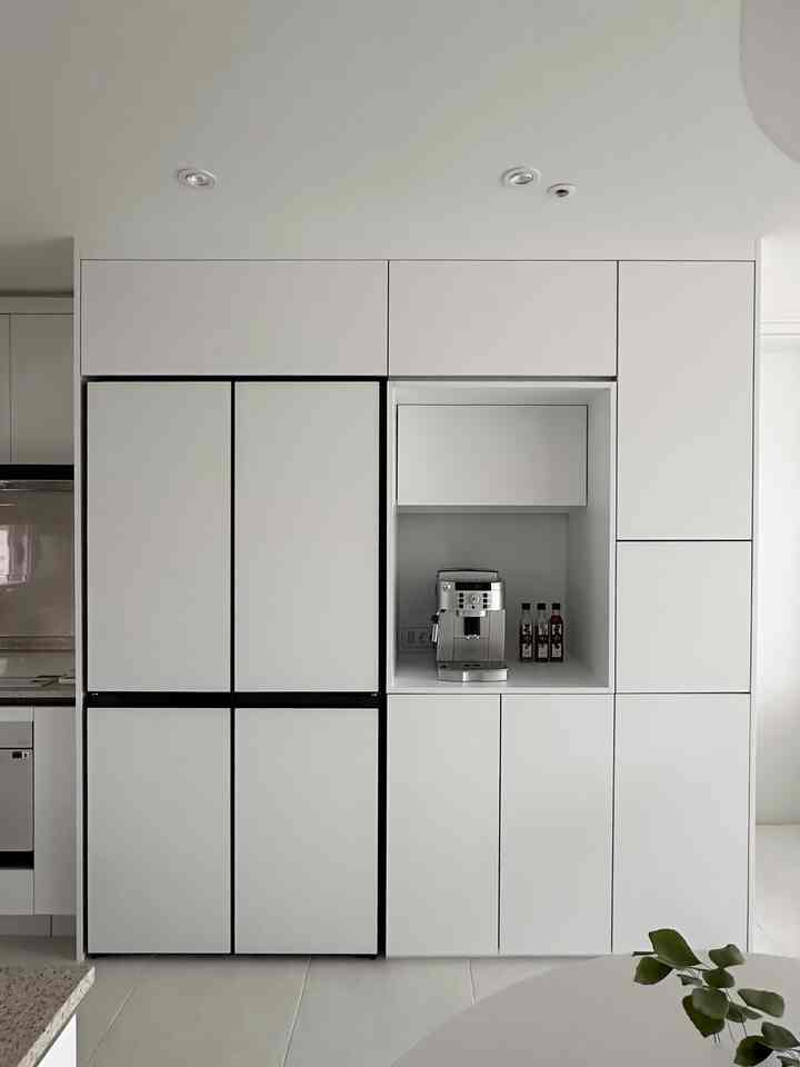 白を基調としたキッチン、キッチンフィット冷蔵庫とオーダーメイド収納が配置されたモダンで清潔感のあるインテリア