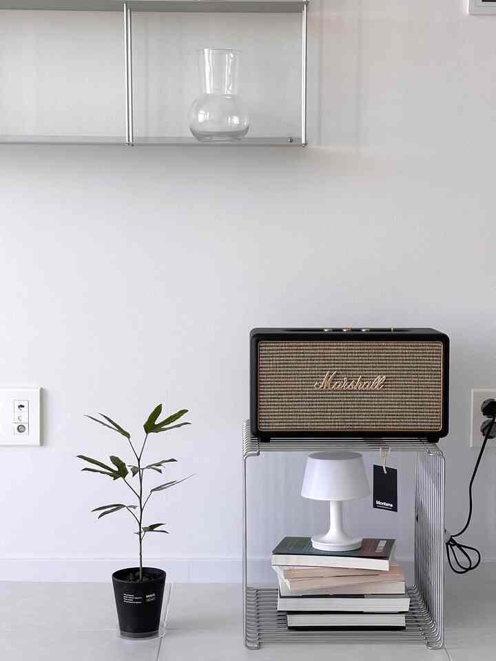 白を基調としたリビング空間、パン톤のワイヤーキューブシェルフにマーシャルスピーカーとムードランプが配置されたシンプルでモダンなインテリア