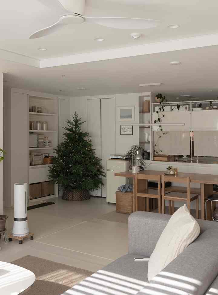 柔らかなナチュラルトーンのリビングとキッチン、木製のダイニングテーブルとグレーのソファが配置された雰囲気のあるインテリア