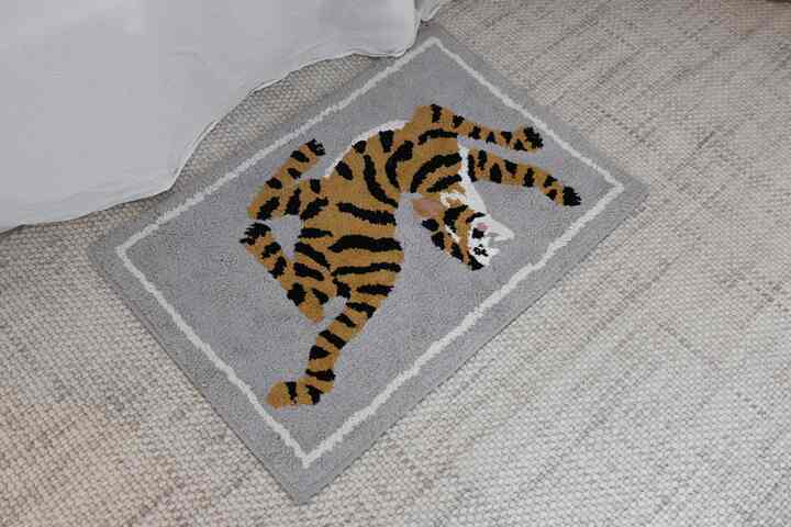 グレーとベージュの床に置かれた虎柄のバスマット、快適でスタイリッシュな雰囲気のある空間