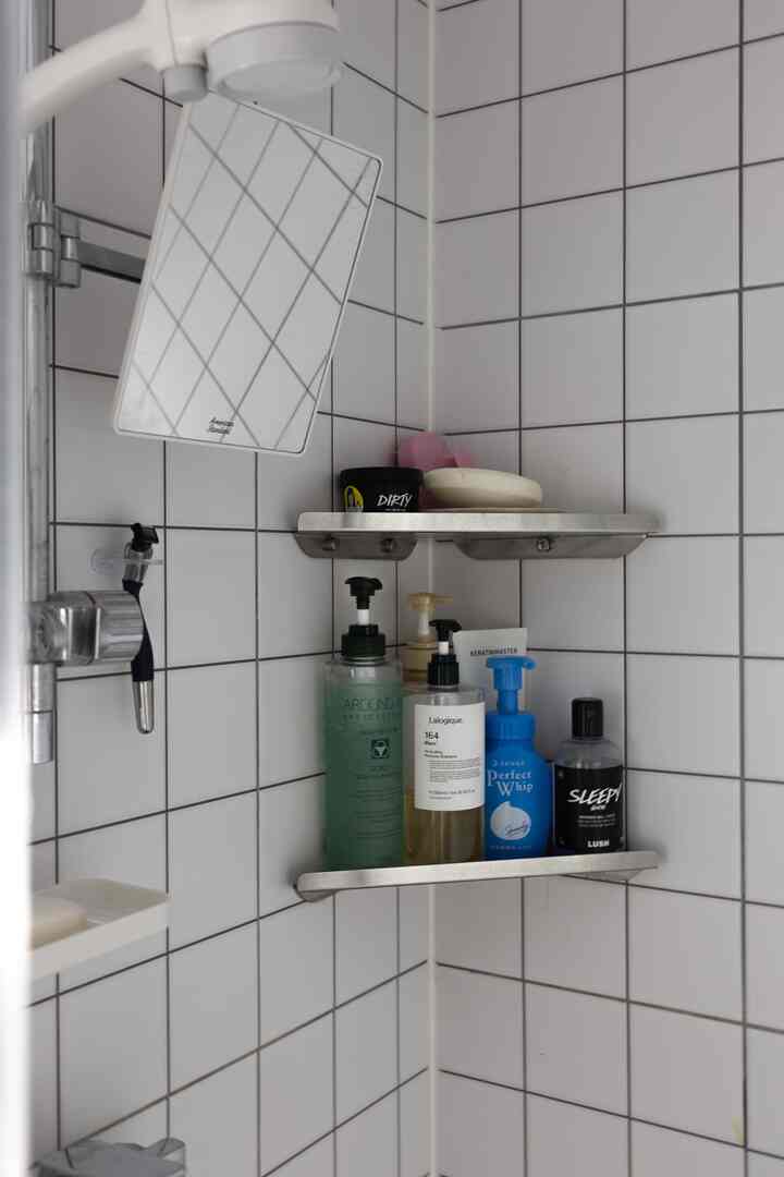 白いタイルとコーナー収納が配置された共用バスルーム、清潔で実用的な雰囲気のインテリア
