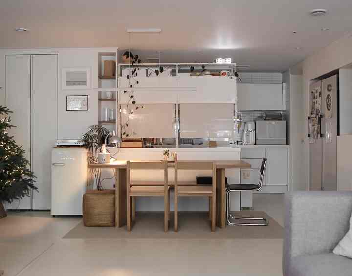 白と木目調の調和が取れたキッチンダイニング空間、シンプルなダイニングテーブルと間仕切りが配置された雰囲気のあるおうちカフェインテリア