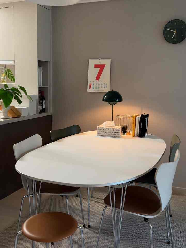 柔らかなベージュとホワイトのトーンのダイニング、フリッツ・ハンセンのテーブルと色違いの椅子が配置された雰囲気のある空間