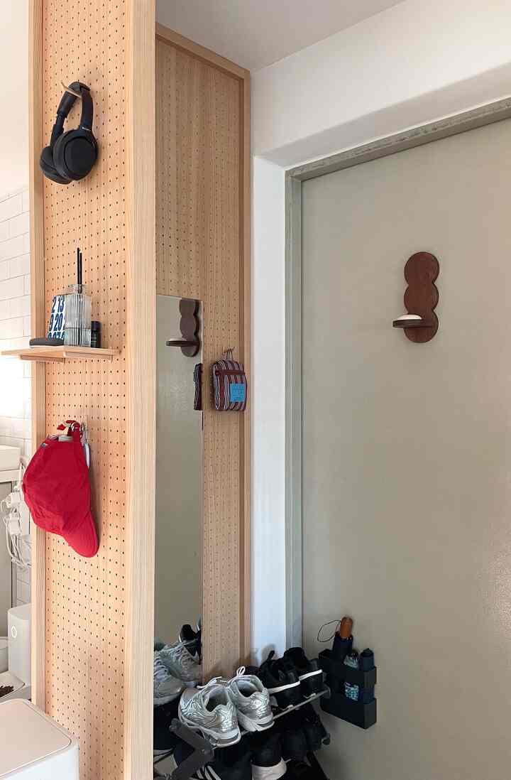 ナチュラルな木目調のパーティションとシューズラックが配置された玄関、実用的な収納アイデアとシンプルな雰囲気のインテリア