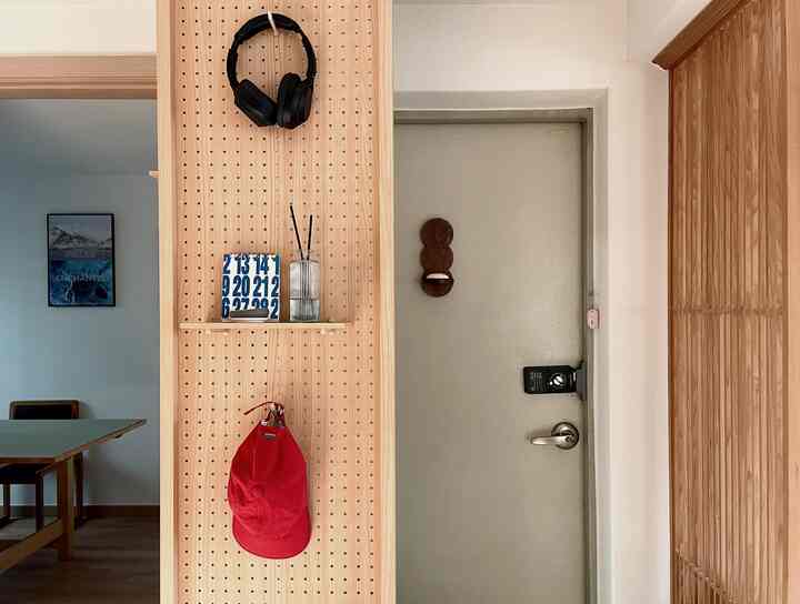 ナチュラルな木目調の玄関と左側にキッチンまたはダイニングスペースの一部が見えるすっきりとした空間