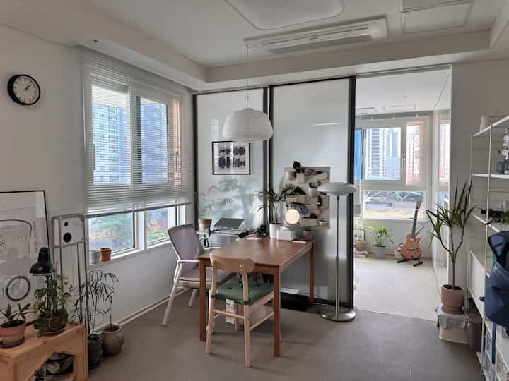 白と茶色のトーンのダイニングルーム、ダイニングテーブルと椅子、ペンダントライトが配置されたモダンでナチュラルな雰囲気のあるインテリア