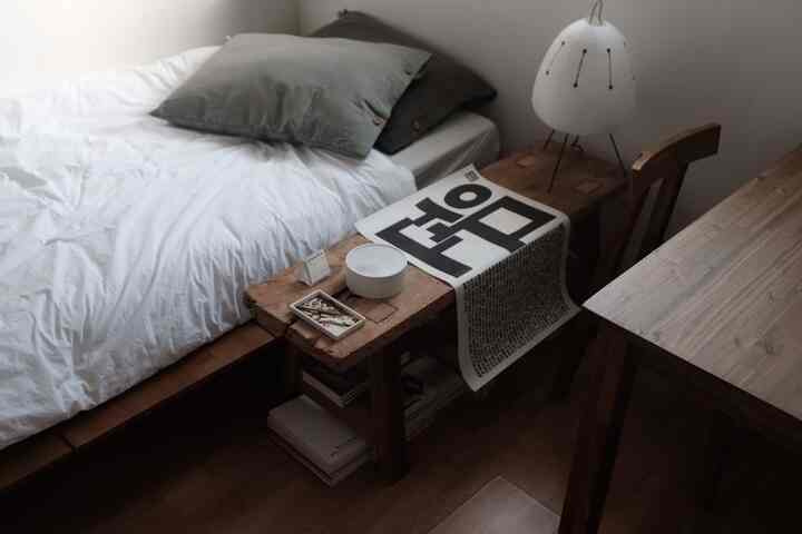 ナチュラルトーンの寝室、白いベッドと木製ナイトテーブルが配置された落ち着いた空間