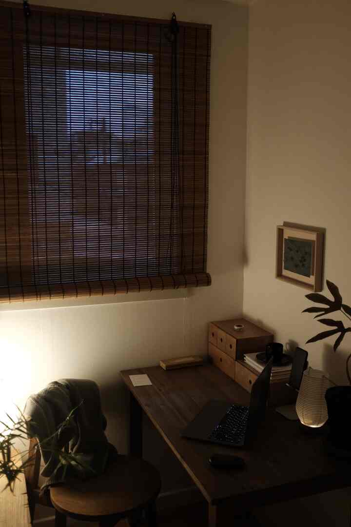 暖かいナチュラルトーンの書斎空間、木製デスクと竹ブラインド、柔らかな照明が配置された居心地の良い作業スペース