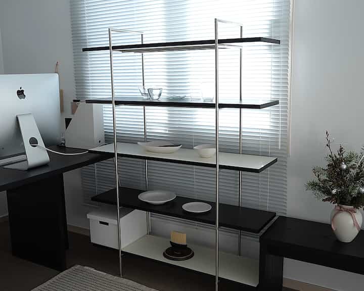 白と黒のトーンのホームオフィス、オープンシェルフとコンピューターが配置されたモダンな作業空間