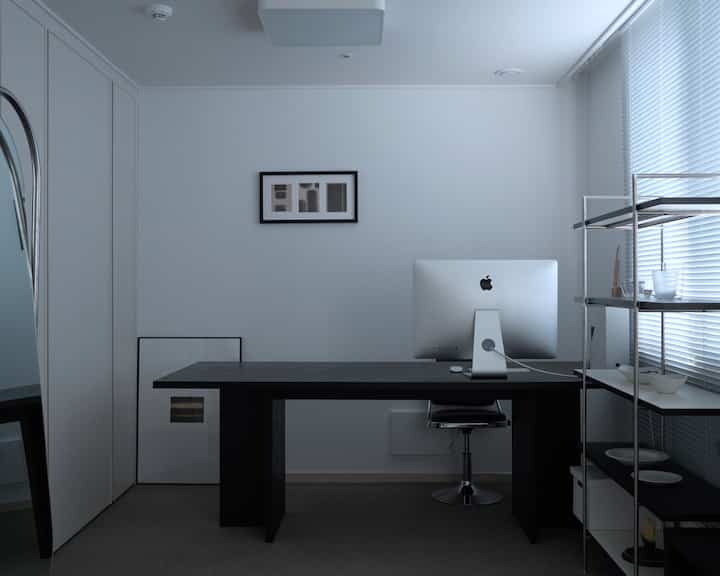 白と黒を基調としたホームオフィス、モダンな机とオフィスチェアが配置された落ち着いた雰囲気のインテリア