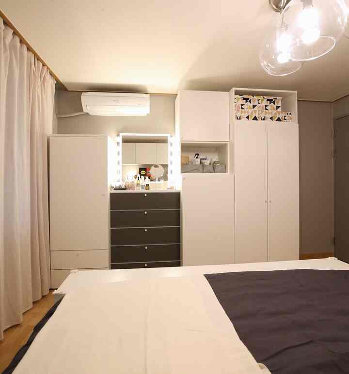 White and dark gray bedroom featuring a tidy bed and dresser with natural wood tones creating warm atmosphere