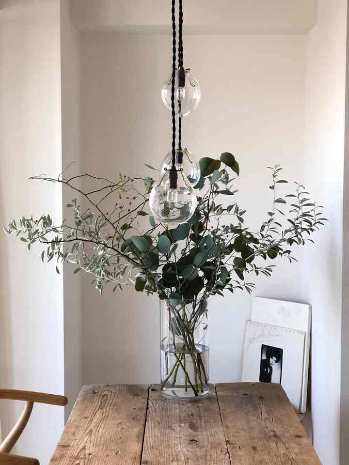 木目調のテーブルと透明な花瓶が配されたシンプルなダイニングの雰囲気あるインテリア