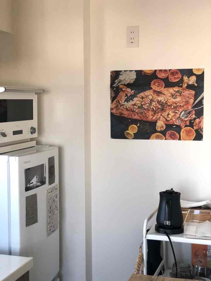 白を基調としたコンパクトなキッチン、キッチンワゴンに黒い電気ケトルや調理器具が整然と配置された雰囲気のあるインテリア