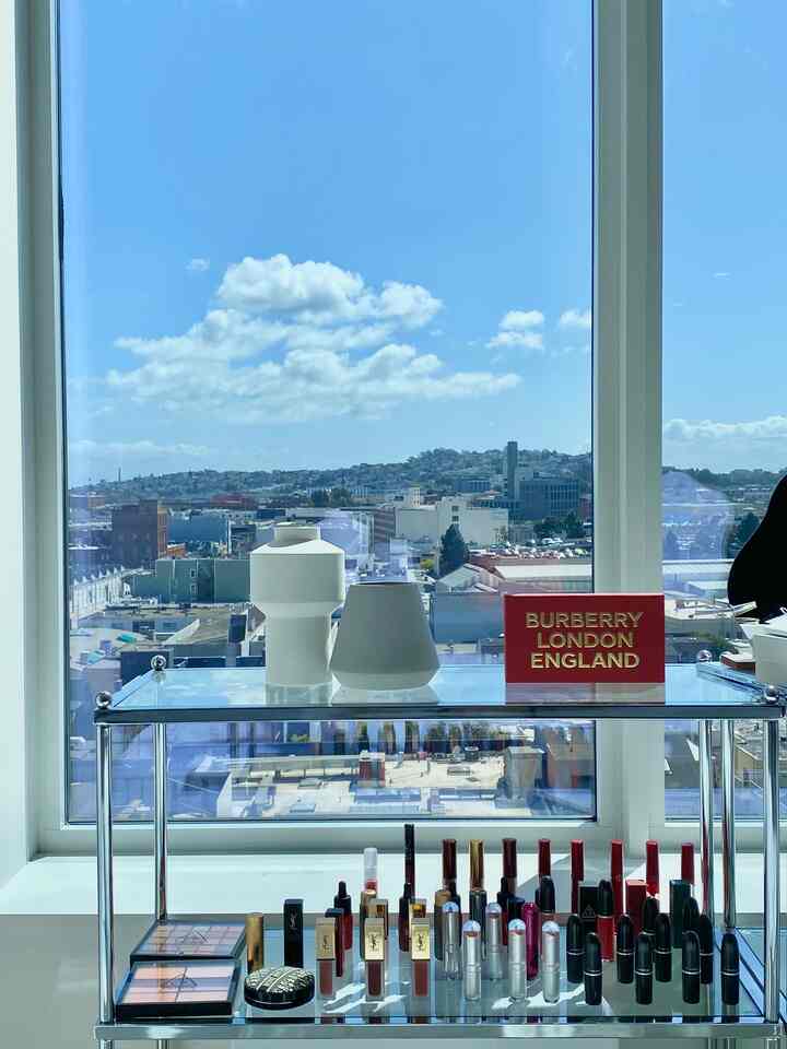 透明なガラス棚にマットなセラミック花瓶二つと赤とゴールドの飾り箱が配置されたモダンなインテリア空間