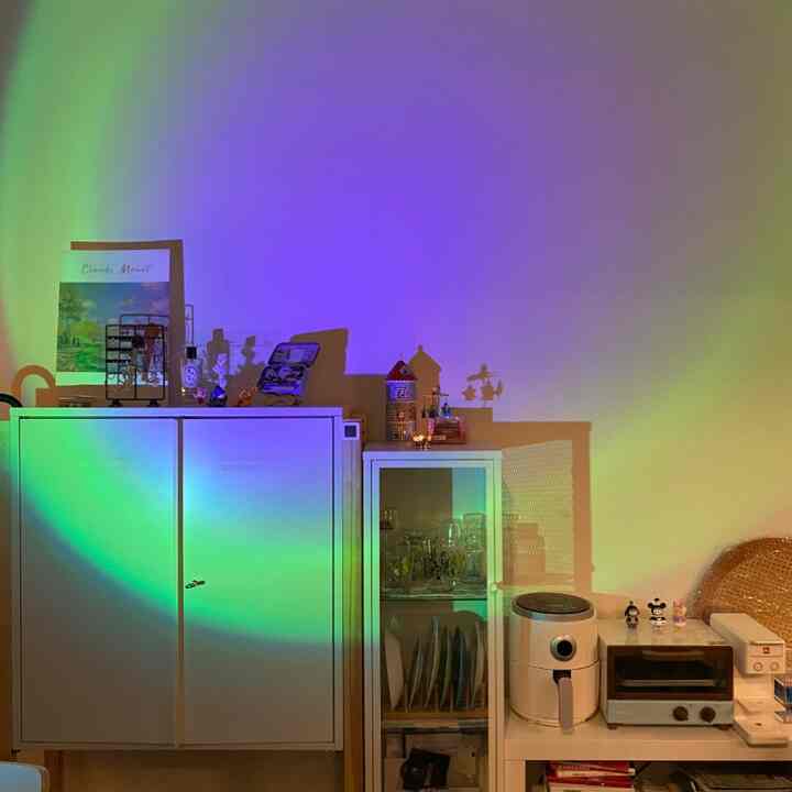 白色調のリビング、キャビネットや食器棚、棚とキッチン家電が配置されたミニマルな空間