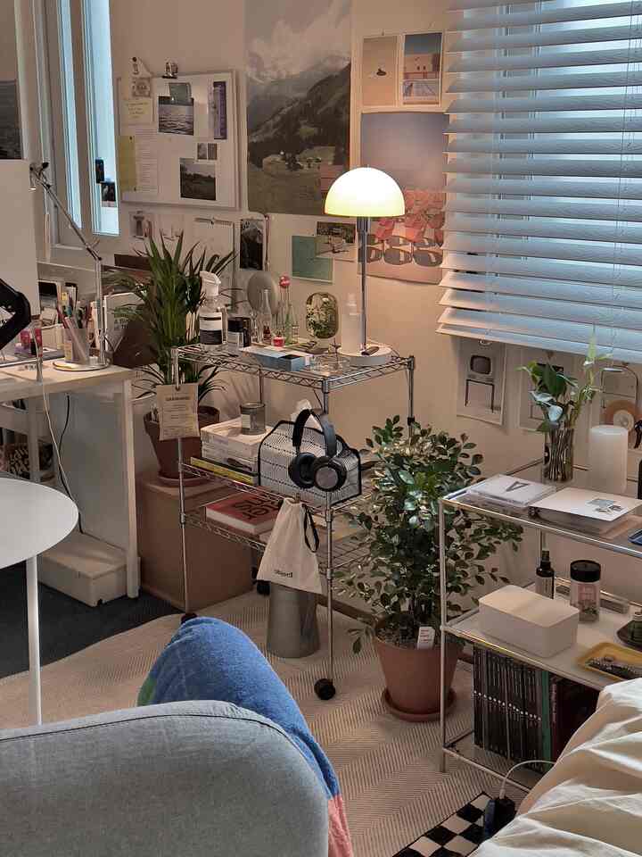 白とグレーのトーンの小さなホームオフィス空間、メタルシェルフと植物が配置された自然で整った雰囲気のインテリア